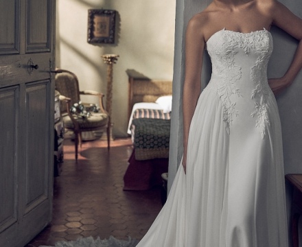 Abito da sposa principesco senza spalline, con ricami floreali sul corpetto e ampio strascico bordato in pizzo, presso Il Giardino Fiorito delle Spose a Roma.