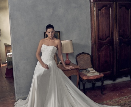 Abito da sposa principesco senza spalline, con ricami floreali sul corpetto e ampio strascico bordato in pizzo, presso Il Giardino Fiorito delle Spose a Roma.
