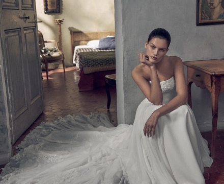 Abito da sposa principesco senza spalline, con ricami floreali sul corpetto e ampio strascico bordato in pizzo, presso Il Giardino Fiorito delle Spose a Roma.