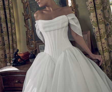 Abito da sposa principesco in mikado con scollatura omerale, fila di bottoncini e ampio strascico, presso Il Giardino Fiorito delle Spose a Roma.
