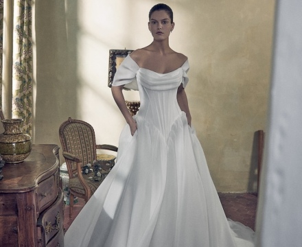 Abito da sposa principesco in mikado con scollatura omerale, fila di bottoncini e ampio strascico, presso Il Giardino Fiorito delle Spose a Roma.