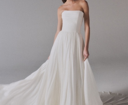 Abito da sposa minimal senza spalline, con gonna fluida e ampio strascico, presso Il Giardino Fiorito delle Spose a Roma.