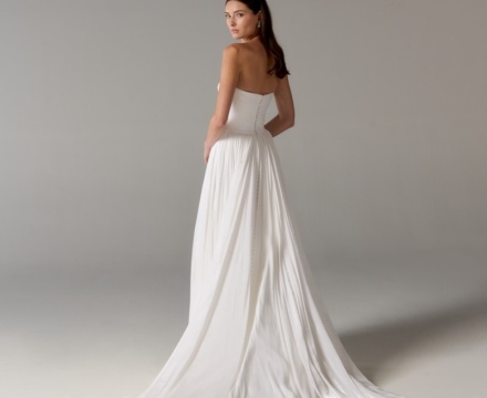 Abito da sposa minimal senza spalline, con gonna fluida e ampio strascico, presso Il Giardino Fiorito delle Spose a Roma.