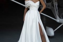 Abito da sposa elegante con scollo a cuore drappeggiato e spacco con gonna ampia e linea strutturata in tessuto liscio, creazione couture atelier Il Giardino Fiorito delle Spose Roma