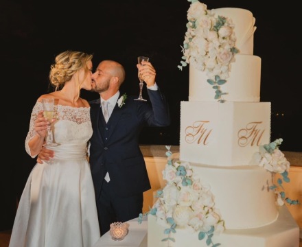 Sposa Il Giardino Fiorito delle Spose in abito in pizzo durante il taglio torta in un momento di brindisi con lo sposo