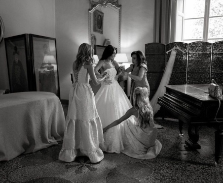 Sposa Il Giardino Fiorito delle Spose durante la preparazione con amiche mentre indossa l’abito da sposa, momento intimo prima della cerimonia