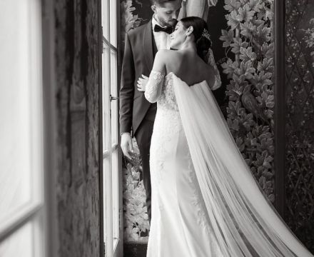 Sposa con abito couture e velo lungo che si bacia con lo sposo a Villa Miani Roma