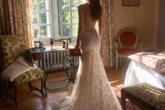 Abito da sposa in pizzo con collo alto e silhouette aderente in ambiente elegante, creazione couture atelier Il Giardino Fiorito delle Spose Roma