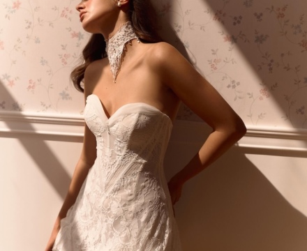 Abito da sposa corto in pizzo con corpetto a bustier e scollatura a cuore, presso Il Giardino Fiorito delle Spose a Roma.