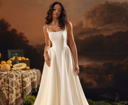 Abito da sposa principesco minimal in raso, con corpetto strutturato, spalline sottili e lungo strascico, presso Il Giardino Fiorito delle Spose a Roma.