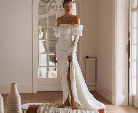 Abito da sposa in pizzo con spalle scoperte e maniche lunghe con spacco e silhouette aderente, creazione couture atelier Il Giardino Fiorito delle Spose Roma
