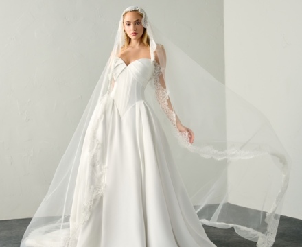 Abito da sposa principesco in mikado con corpetto strutturato e lungo velo bordato in pizzo, disponibile presso Il Giardino Fiorito delle Spose a Roma.